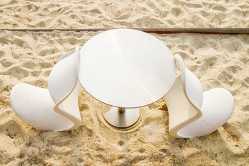 White table and chairs on the sand