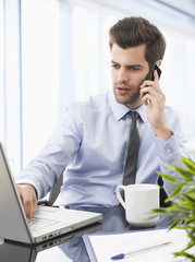 Smiling businessman talking on a mobile phone.