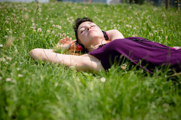 beautiful hipster short hair woman listening music in the park