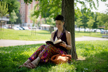 beautiful hipster short hair woman reading book in the park