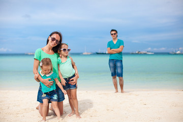 Naklejka premium Mom with her cute daughters in the foreground and dad in the