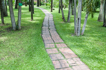 brickbat path on green grass in garden