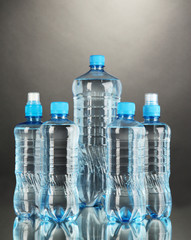 Different water bottles on grey background