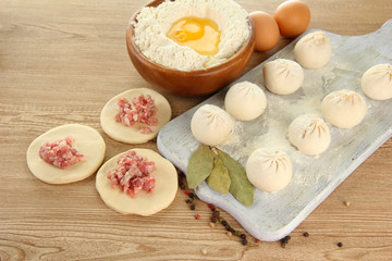 Raw dumplings, ingredients and dough, on wooden table