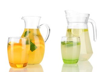 Orange and lemon lemonade in pitchers and glasses isolated