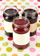 Tasty jam in banks on table