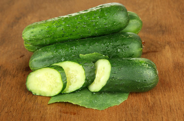 Tasty green cucumbers on wooden background