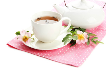 Cup and teapot of herbal tea with hip rose flowers, isolated
