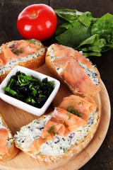 Fish sandwiches on cutting board on wooden table