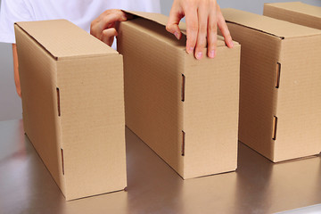 Worker working with boxes at conveyor belt, on grey background