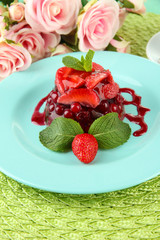 Tasty jelly dessert with fresh berries, on bright background