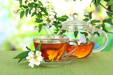 Cup of tea with jasmine, on bamboo mat, on bright background