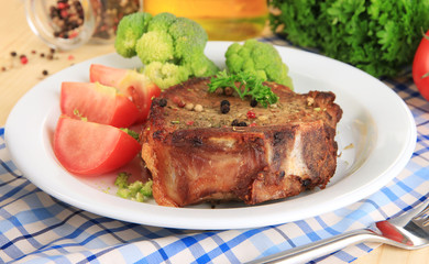 Piece of fried meat on plate on wooden table close-up