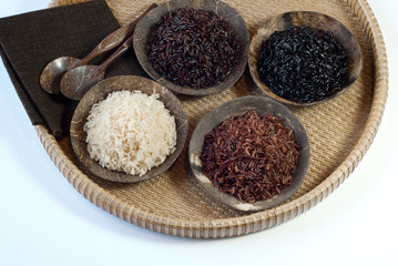 4 bowls of raw rice; brown, red, black, and black sweet rice
