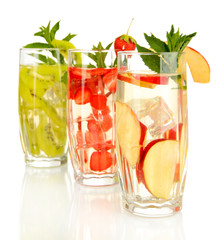 Glasses of fruit drinks with ice cubes isolated on white