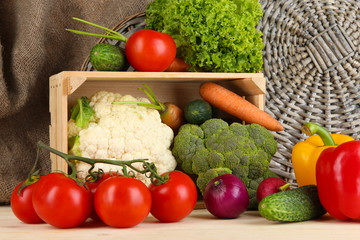 Fresh vegetables in wooden box on table close up