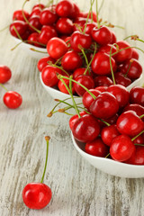 Cherry berries in bowl on wooden table close up