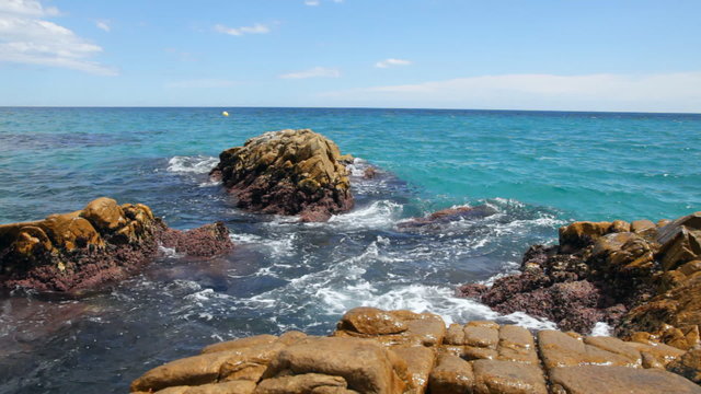 The waves breaking on a stony coastline in Platja D'Aro, Spain