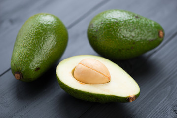 Avocado pears: two whole and one cut, horizontal shot