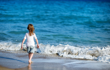 Adorable little girl on a sandy beach