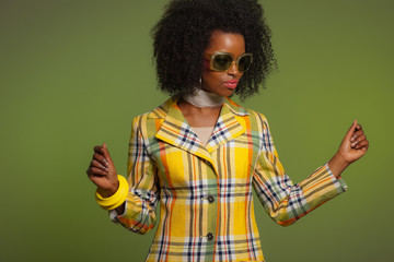 Dancing retro 70s fashion african woman with sunglasses. Yellow