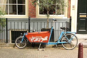 Tricycle against a facade of a house in Amsterdam