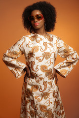 Retro 70s fashion african woman with paisley dress and sunglasse