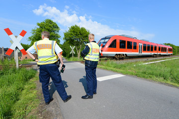Polizisten vor Bahnübergang