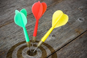 Darts hitting  target on a wooden planks