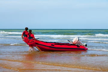 Foto op Canvas Two rescuers pulled the boat ashore. © ARTENS