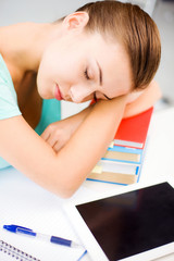 tired student sleeping on stock of books