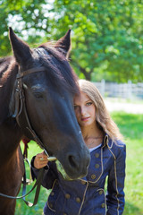 Fototapeta premium Young girl walking with a horse in the garden.