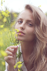Portrait of a sexy blond girl in a field of yellow flowers