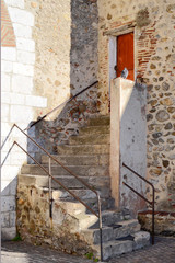 Obraz premium vieil escalier conduisant à une petite porte rouge