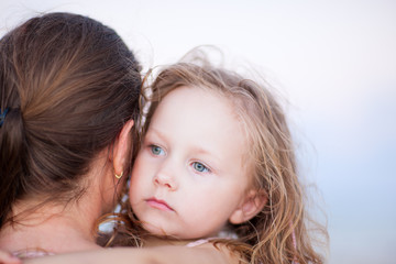 Little girl held by her mother