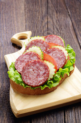 Sandwich with sausage, tomato and cucumber