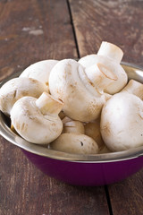 Bunch of fresh white mushrooms in the purple bowl