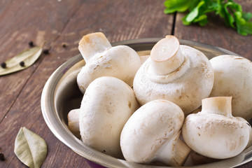 Bunch of fresh white mushrooms in the purple bowl
