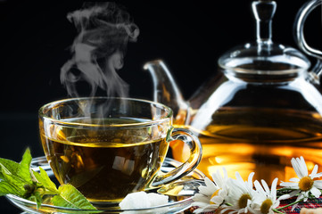 Cup with green tea and green leaves.
