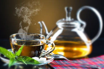 Cup with green tea and green leaves.