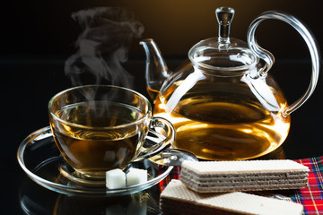 Cup with green tea and green leaves.