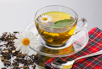 Cup with green tea and green leaves.
