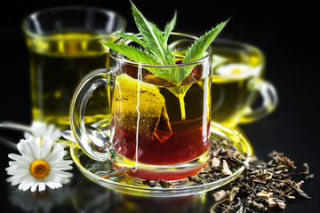 Cup with green tea and green leaves.