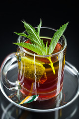 Cup with green tea and green leaves.