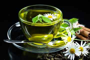 Cup with green tea and green leaves.