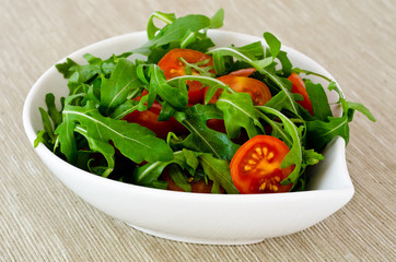 bowl of fresh green, natural arugula and cherry tomatoes