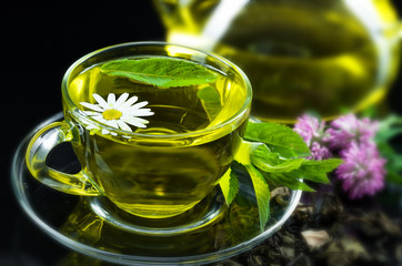 Cup with green tea and green leaves.