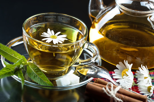 Cup with green tea and green leaves.