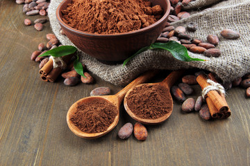 Cocoa powder and cocoa beans  on wooden background