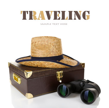 Black modern binoculars with suitcase and straw hat isolated